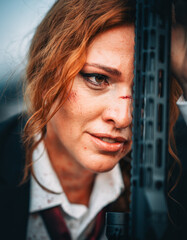 Redhead woman in a suit with a rifle
