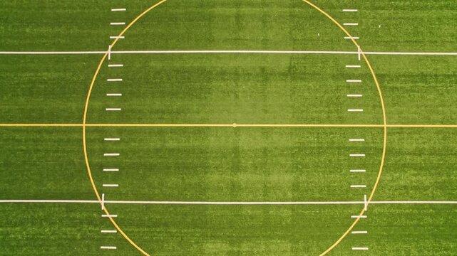 Soccer field top straight down aerial shot zoom out. Empty football playground. Sport stadium green grass and white paint lines and marks for games and activity. Healthy lifestyle.