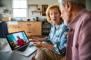Senior couple concerned during video call in home kitchen