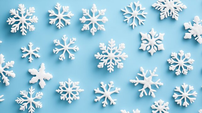 Stunning collection of diverse white snowflakes scattered across a vibrant blue background, perfect for winter holiday designs and festive celebrations.