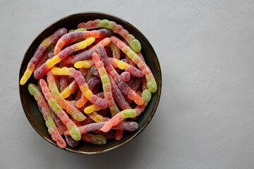 Sugary Sour Gummy Worms in a Bowl, top view. Copy space.
