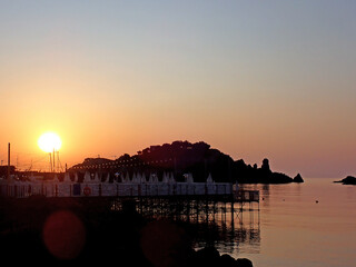Isola Lachea in silhouette al tramonto con pontile e mare calmo 1659