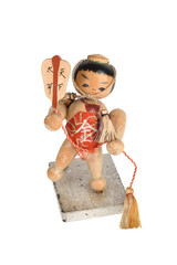 Close-up of a vintage Japanese wooden figurine with decorative tassels.