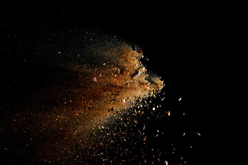 Brown powder explosion isolated on black background