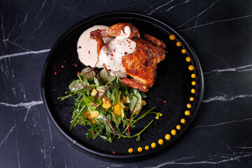 Roasted Chicken Leg Plate with Fresh Greens and Sauces on Dark Marble