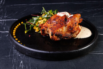 Roasted Chicken Leg Plate with Fresh Greens and Sauces on Dark Marble