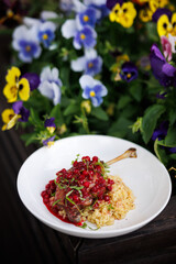 Lamb Rack With Pomegranate Glaze And Creamy Risotto In A Colorful Garden Setting