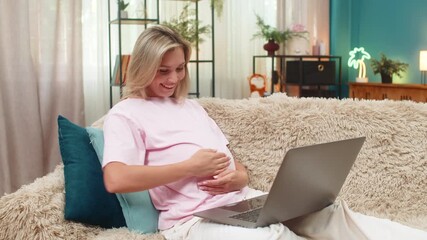 Pregnant middle-aged woman at home wins online game on laptop after positive news raising fist celebrating freelance success. Caucasian girl on sofa feels joyful hope cheering future wealth ahead big. - Powered by Adobe
