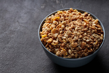 Granola Cereal in Ceramic Bowl on Dark Stone Background Copy Space