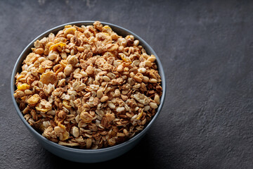 Granola Cereal in Ceramic Bowl on Dark Stone Background Copy Space