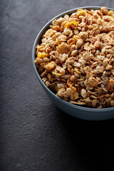 Granola Cereal in Ceramic Bowl on Dark Stone Background Copy Space