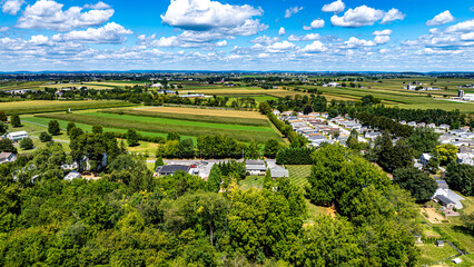 Lush green fields and rural homes are seen from above, showcasing the beauty of farmland and a...