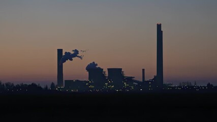 This dramatic video captures the silhouette of a coal power plant against the twilight sky. It highlights the significant role of fossil fuels in energy production and raises awareness about environme