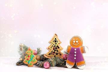 Festive winter greeting card and banner on the screen, New Year's gingerbread and Christmas decorations on snowy fir branches, Christmas and New Year's background with lights and decorations