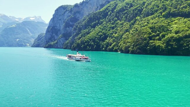 Aerial drone view of Swiss cruise boat on Lake Lucerne in central Switzerland. Beautiful Swiss Alps mountains, alpine lake in summer. Turquoise blue water. 