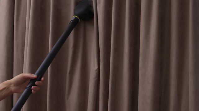 Curtains steaming demonstration, Steamer smooths out wrinkles on soft velvet curtain fabric, Handheld nozzle releases delicate mist to freshen and straighten curtain folds