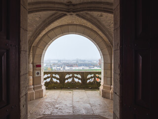 France, Amboise, November 11, 2025. Panoramic view of the town of Amboise, France, captured through the Gothic stone arch of the castle