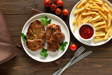 Roasted pork steaks and french fries with tomato sauce