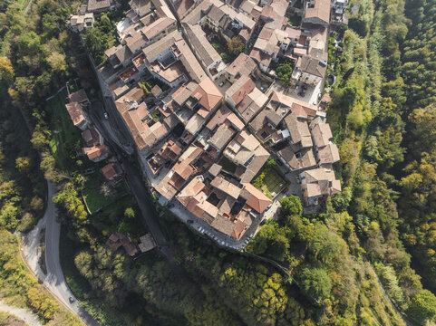 Aerial view of the terracotta rooftops of ancient buildings nestled within lush greenery, a medieval village clinging to the hillside, Sant Agata de Goti, Campania, Italy.