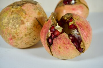 Ripe pomegranates bursting open showing red seeds