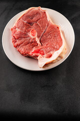 Bone-in ham steak, raw pork ham on the bone tasty snack fresh gourmet food background on the table  rustic food top view copy space