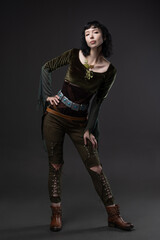 A fighting forest elf, a costumed image of a fantasy heroine. A young brunette with short black hair, in the image of a warrior from the forest, a blouse made of light flying fabrics and a leather