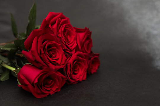 Vibrant red roses arranged elegantly against a dark background for a romantic touch