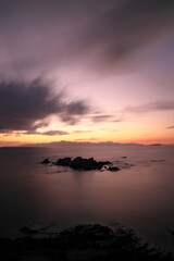 A small rock at sunset in the Aegean Sea. Long exposure technique. Selective focus.