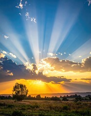Vibrant sun rays burst through clouds over a serene field at sunset