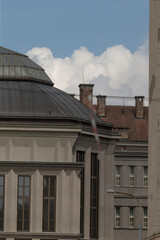 large classical dome rising above mixed rooftops and chimneys, layered skyline with cloudy sky evokes timeless