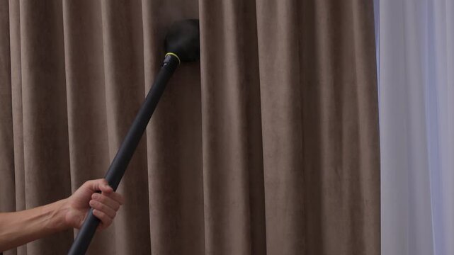 Curtains steaming demonstration, Steamer smooths out wrinkles on soft velvet curtain fabric, Handheld nozzle releases delicate mist to freshen and straighten curtain folds