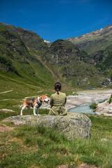 Woman and beagle by mountain river