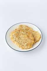 Pan fried meat schnitzel cutlets on plate, golden and crispy, studio shot on white