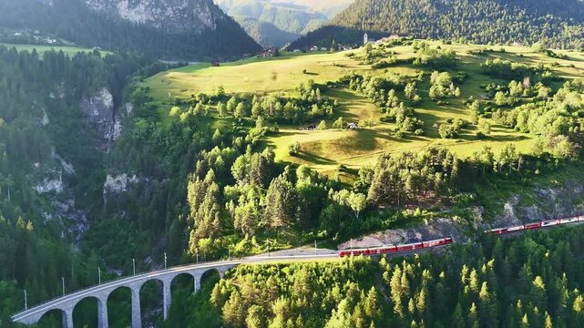 red swiss train on Landwasser viaduct bridge in Swiss Alps. Zermatt to St. Moritz.  scenic railway. Switzerland summer tourism.
