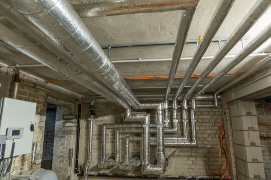 Industrial piping system with metallic ducts in a commercial building interior