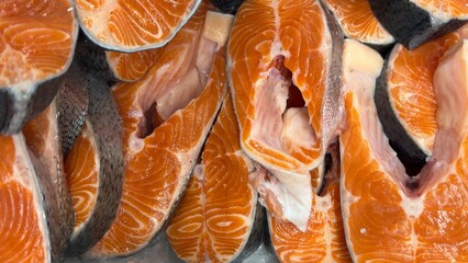 Vibrant Seafood Market: Diverse Selection of Fresh and Frozen Salmon Fish Slices Displayed in Icy Bins. Perfect for Showcasing Quality, Variety, and Culinary Delights in a Dynamic Retail Environment