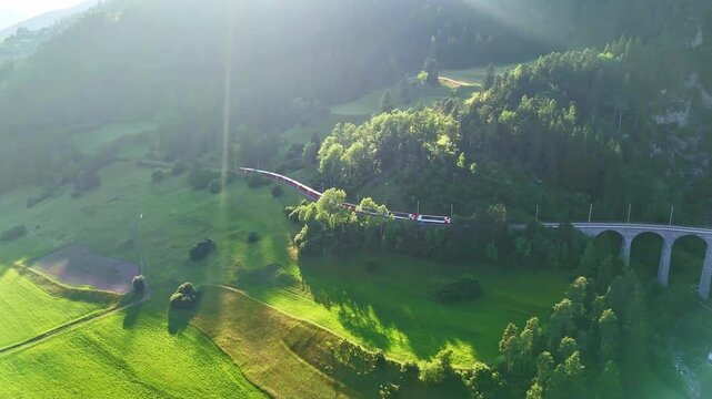 red swiss train on Landwasser viaduct bridge in Swiss Alps. Zermatt to St. Moritz.  scenic railway. Switzerland summer tourism.