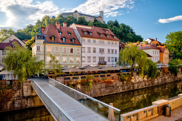 Ljubljana, Slovenia – July 14, 2025: Early morning in the historic city center with a clear view of Ljubljana Castle on the hilltop and traditional European buildings lining the quiet cobblestone stre