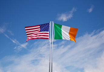 flags of ireland and United States of America over blue sky background.