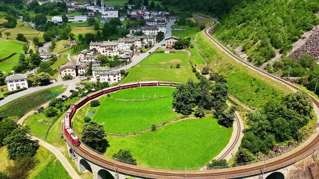 Drone Switzerland 4k.  train on way to St. Moritz. Brusio spiral viaduct, stone spiral railway viaduct on the Bernina Railway. Swiss Alps in summer. 
