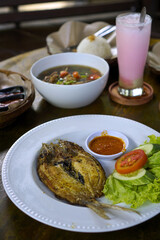 Indonesian grilled or fried Milkfish served with fresh lettuce, sambal, and vegetables. Ideal for menus.