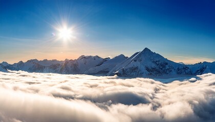Snow Capped Mountain Peaks Rise Above A Sea Of Clouds Under A Bright Sun