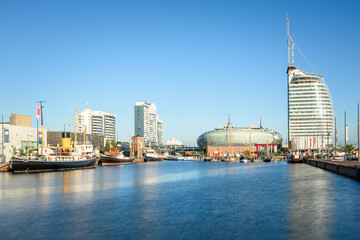 Boats in a harbour surrounded by modern and traditional architecture on a clear summer day. Long exposure. Bremerhaven, Germany.
