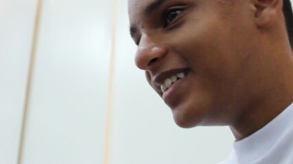 Portrait of an Afro-Colombian boy speaking and smiling against a white background inside a classroom in Neiva, Huila, Colombia. Concept of black people and education - Powered by Adobe