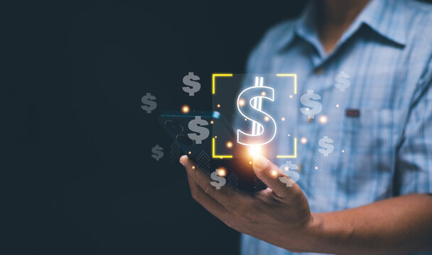 Mobile financial management concept. Businessman holding a smartphone and glowing dollar icons. symbolizing online payments, mobile banking, fintech transactions and modern money management.