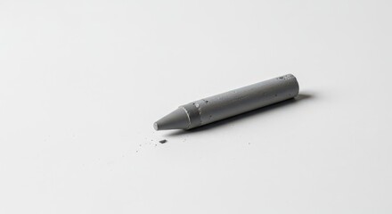 Fototapeta premium A lonely, broken, gray crayon lies isolated on a white surface, symbolizing neglect, forgotten creativity, and the melancholy of being unused, sadness, stationery, wax