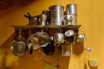 Rustic kitchen utensils hanging on a wall shelf in rural Paraíba, Brazil