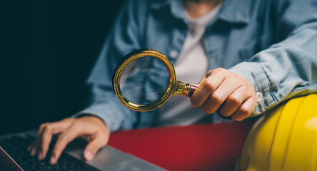 Magnifying glass with laptop and safety helmet, inspection awareness, workplace responsibility...