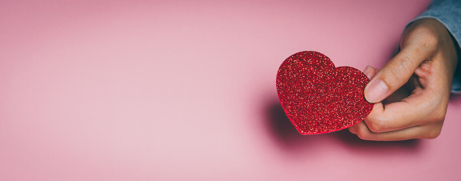 Hand holding glitter red heart, emotional support awareness, kindness expression, mental wellbeing reflection, compassion encouragement insight, love appreciation concept