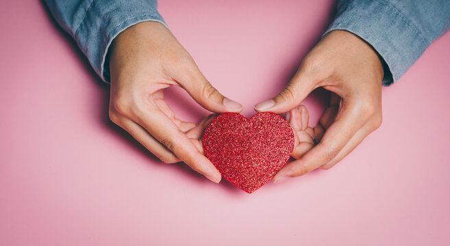 Hands framing glitter red heart, emotional wellbeing awareness, kindness expression, compassion support insight, mental care reflection, love appreciation and positive connection concept